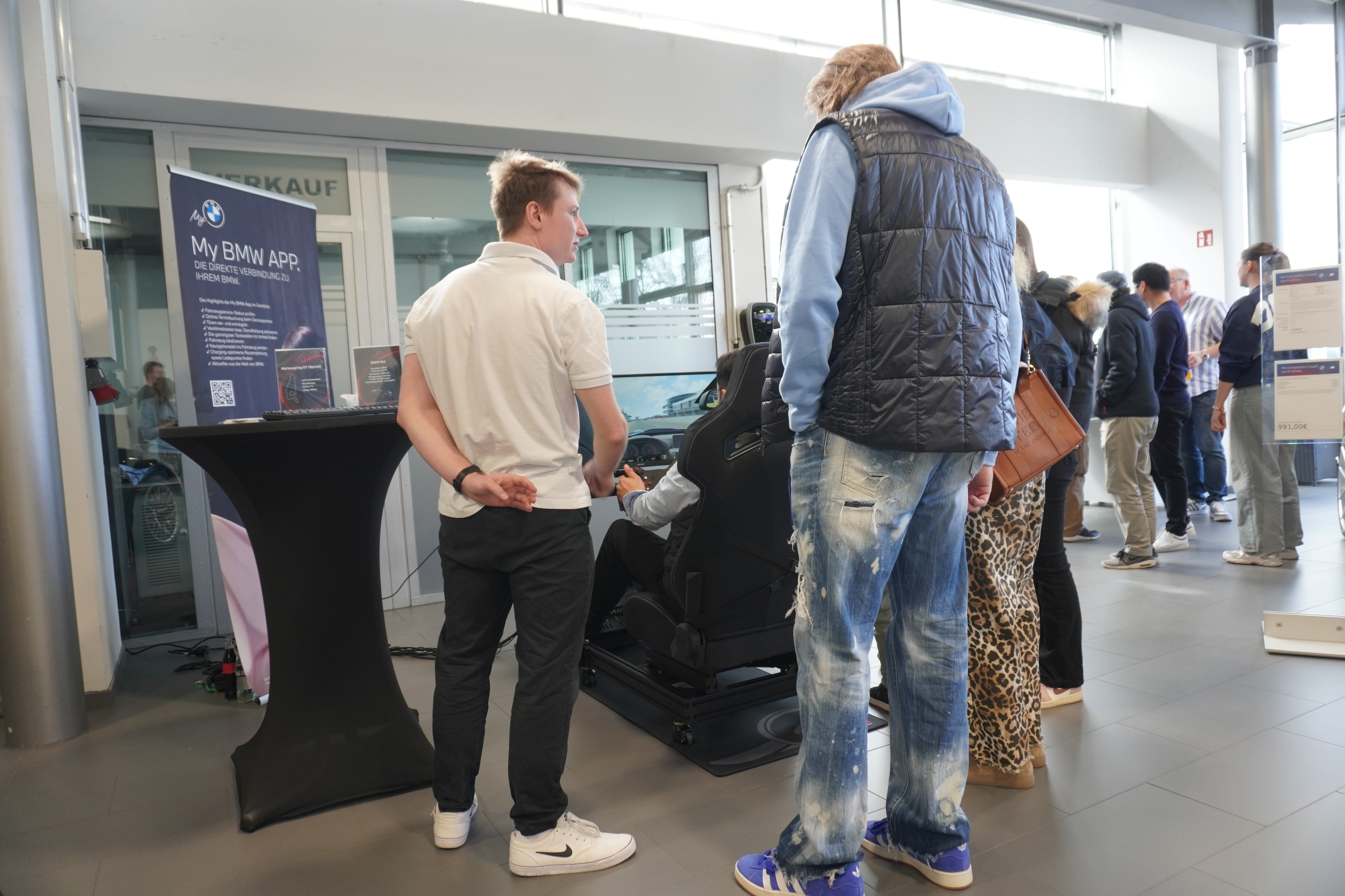 Publikum verfolgt die Simulator-Rennen am Stand
