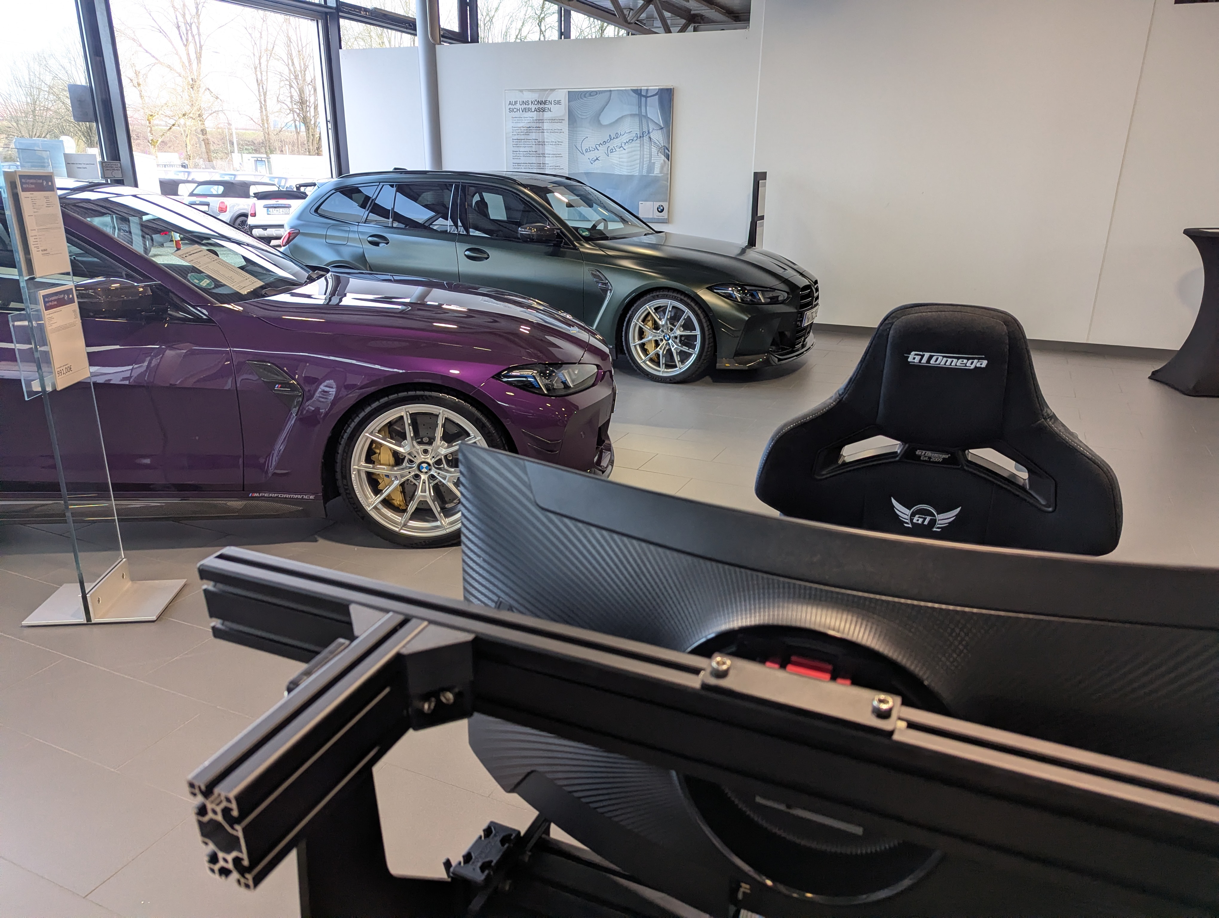 SimRig als Eyecatcher im Showroom mit Fahrzeugen im Hintergrund